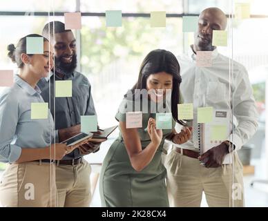 Sticky note, planning meeting and business people thinking of creative idea, writing strategy on paper and happy with team building goal in office Stock Photo