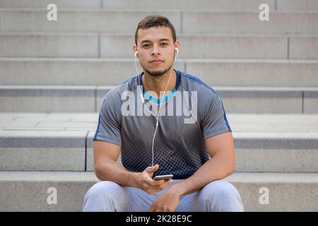 Listening to music young latin man listen smartphone smart phone Stock Photo