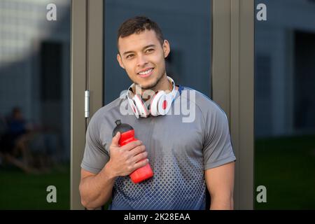 Smiling young latin man looking up runner outdoor sports fitness training Stock Photo