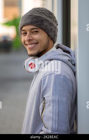 Smiling young latin man sports training with headphones portrait format Stock Photo