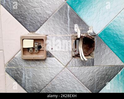 Switches on the old wall. Broken socket and switch. Stock Photo