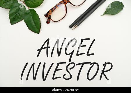 Conceptual caption Angel Investor. Business showcase high net worth individual who provides financial backing Office Supplies Over Desk With Keyboard And Glasses And Coffee Cup For Working Stock Photo