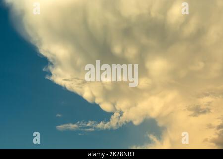 White-gray mammatus clouds against a blue sky Stock Photo