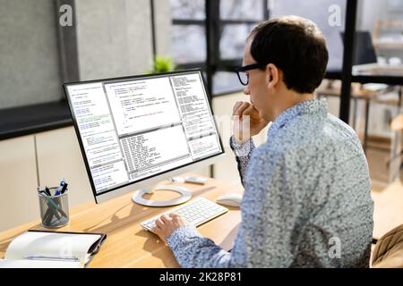 Computer Programmer Writing Program Code On Computer Stock Photo