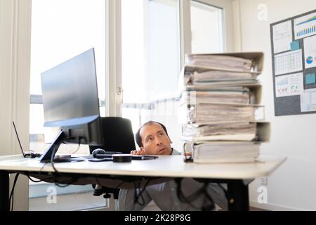 Overworked Business Man With Stack Or Pile Stock Photo