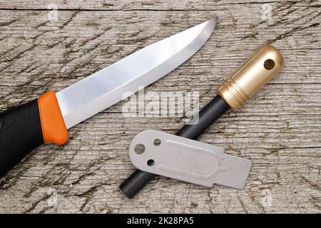 fire starter and camping knife on grungy wooden background Stock Photo