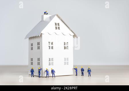 Figurines of builders working on a house Stock Photo
