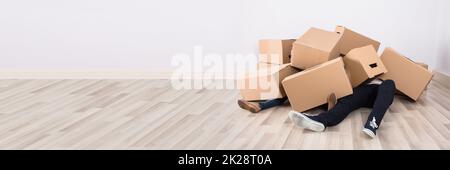 Funny Accident While Moving Boxes. Falling Cardboard Box Stock Photo