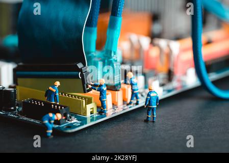 Miniature technicians assembling desktop PC Stock Photo