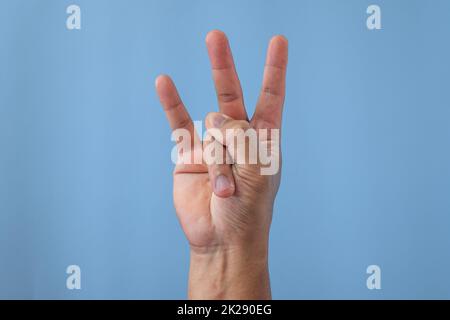 Office syndrome concept. Ring finger is stretched after working. Close up shot isolates on blue background. Forehand view. Stock Photo