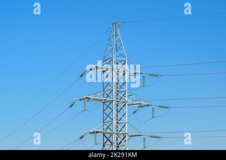Supports high-voltage power lines against the blue sky Stock Photo