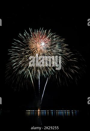 Colorful fireworks with reflection on lake Stock Photo