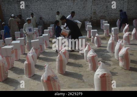 Peshawar, Pakistan. 22nd Sep, 2022. People affected by floods receive relief aid distributed by the Al Khidmat Foundation in Nowshera District, Garhi Momin Village, Khyber Pakhtunkhwa province. (Photo by Hussain Ali/Pacific Press) Credit: Pacific Press Media Production Corp./Alamy Live News Stock Photo