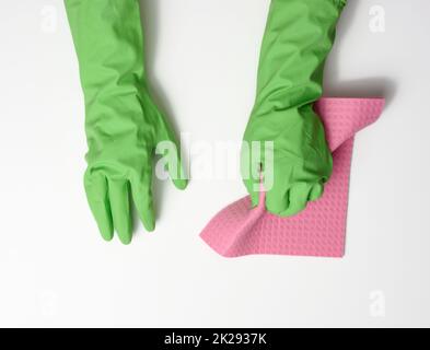 hand in a green rubber glove holds a soft sponge for cleaning surfaces on a white background Stock Photo