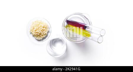 Candelilla Wax in Chemical Watch Glass, Potassium Permanganate and Nickle chloride liquid in test tube place on white laboratory table. Top view Stock Photo
