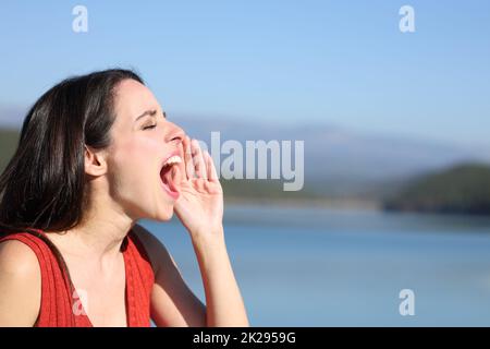 Woman screaming loud in a lake Stock Photo