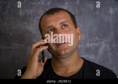 A young man is talking on the phone. Stock Photo