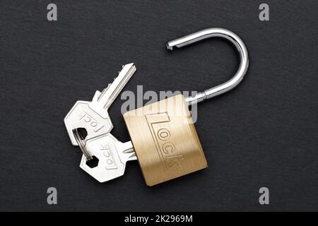 Steel padlock with key on a black background Stock Photo