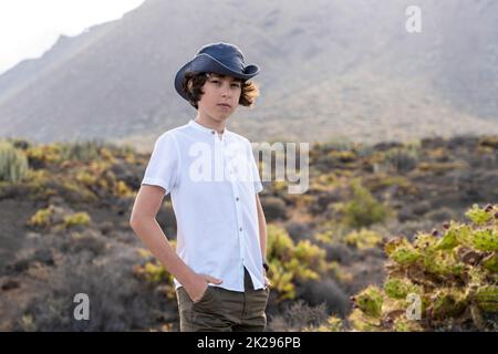 Portrait of a teenager against the backdrop of the Los Gigantes cliffs. View from cape Teno. Tenerife. Canary Islands. Spain. Stock Photo