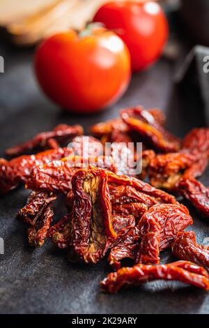 Sun dried tomatoes on black table. Stock Photo