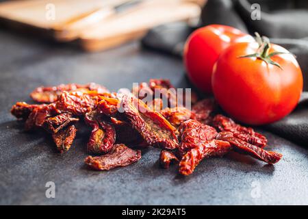 Sun dried tomatoes on black table. Stock Photo
