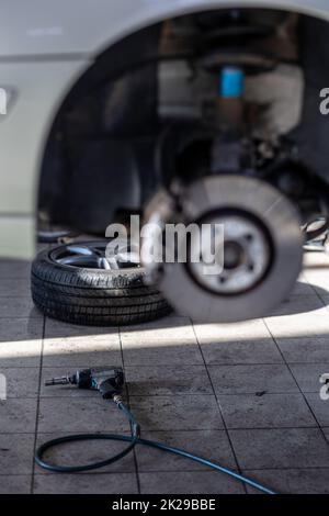 Car in a garage for maintenance, oil/tyre change (shallow DOF  color toned image) Stock Photo