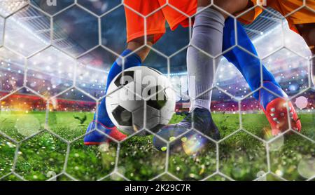 soccer player kicks the ball into the goal at the stadium Stock Photo ...