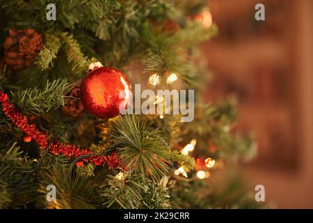 Sparkly Christmas cheer. Closeup shot of a red christmas ornament hanging on the tree. Stock Photo