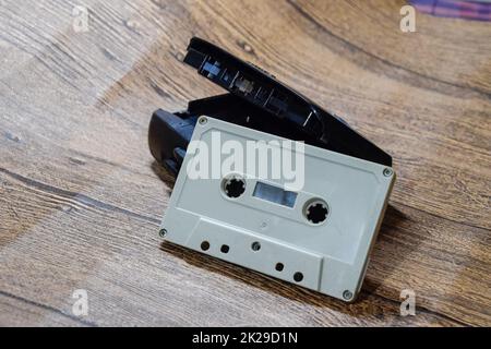 Retro audio cassettes next to a portable player to play compact cassettes. Stock Photo