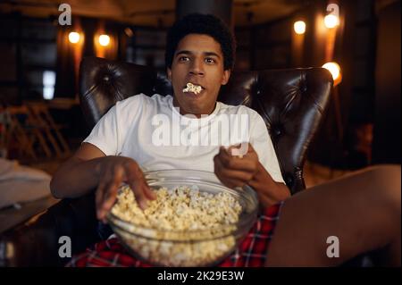 Excited Man Watching Movie Using Projector Eating Popcorn At Home