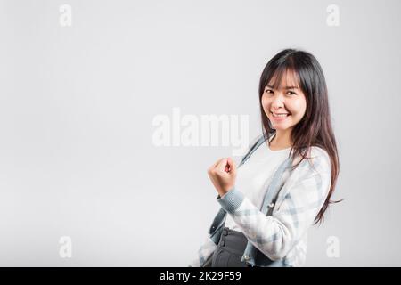 Smiling happy woman makes raised fists up celebrating her winning success gesture Stock Photo