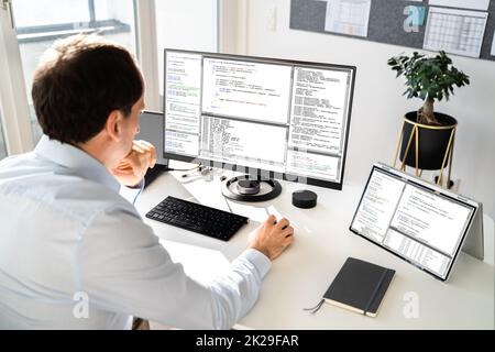 Computer Programmer Writing Program Code On Computer Stock Photo