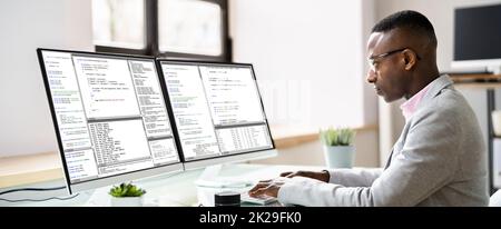 Computer Programmer Writing Program Code On Computer Stock Photo