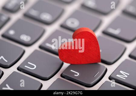 Small red heart on computer keyboard. Internet dating concept. Stock Photo