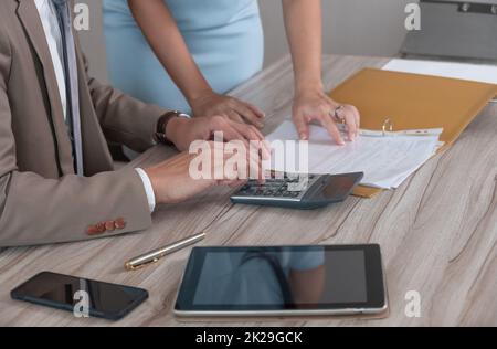Businessman working with calculator for analysis business document and discussing paperwork data with female colleague. Business team concept. Stock Photo