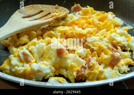 Scrambled eggs with bacon in a pan Stock Photo