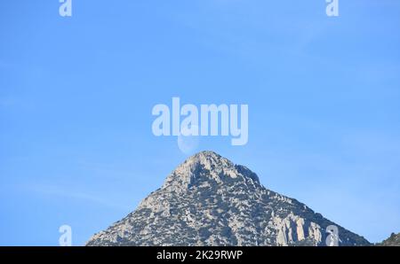 the moon, just before colliding with the mountain, Alicante province, Costa Blanca, Spain Stock Photo