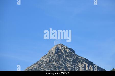 the moon, just before colliding with the mountain, Alicante province, Costa Blanca, Spain Stock Photo