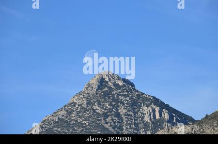 the moon, just before colliding with the mountain, Alicante province, Costa Blanca, Spain Stock Photo