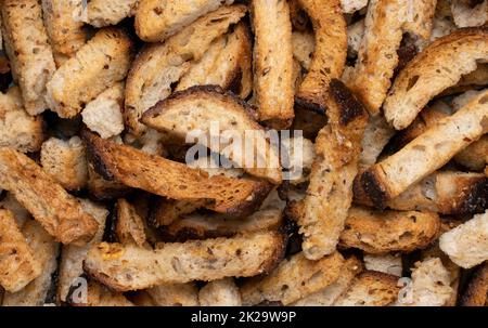 Rye bread fried croutons with garlic as background. Stock Photo