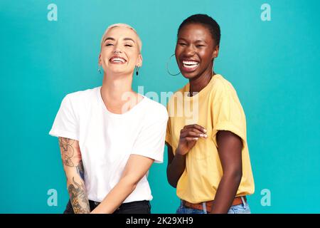 Life is beautiful with your bestie by your side. Studio shot of two happy young women posing together against a turquoise background. Stock Photo