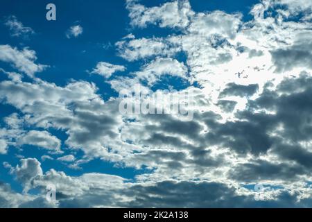 Blue sky with thunderclouds. The sun breaks through the clouds. Black clouds. Stock Photo