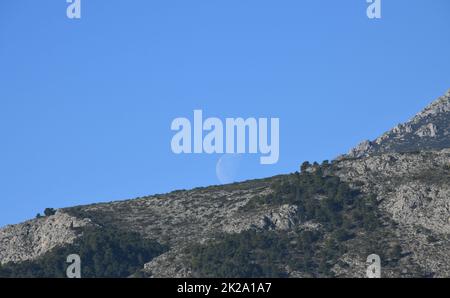 the moon, just before colliding with the mountain, Alicante province, Costa Blanca, Spain Stock Photo