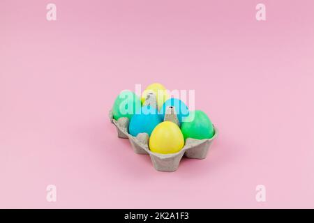 Box with colorful Easter eggs on a pink background Stock Photo