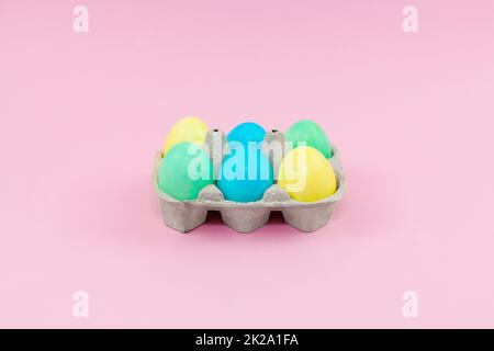 Box with colorful Easter eggs on a pink background Stock Photo
