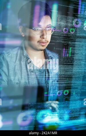 Writing code is what he does. Cropped shot of a young computer programmer looking through data. Stock Photo