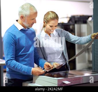 Assuring quality from start to finish. Two publishers assessing the quality of printed work in a factory. Stock Photo