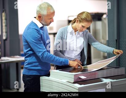 This is good work.... Two publishers assessing the quality of printed work in a factory. Stock Photo