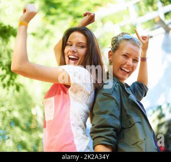 Dancing to the beat of their own drum. Two joyful young women dancing outside. Stock Photo