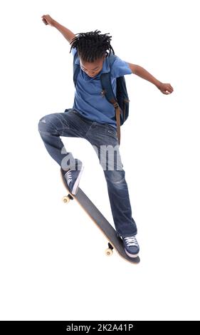 Showing off his mad skills. A young African-American boy doing a trick on his skateboard. Stock Photo